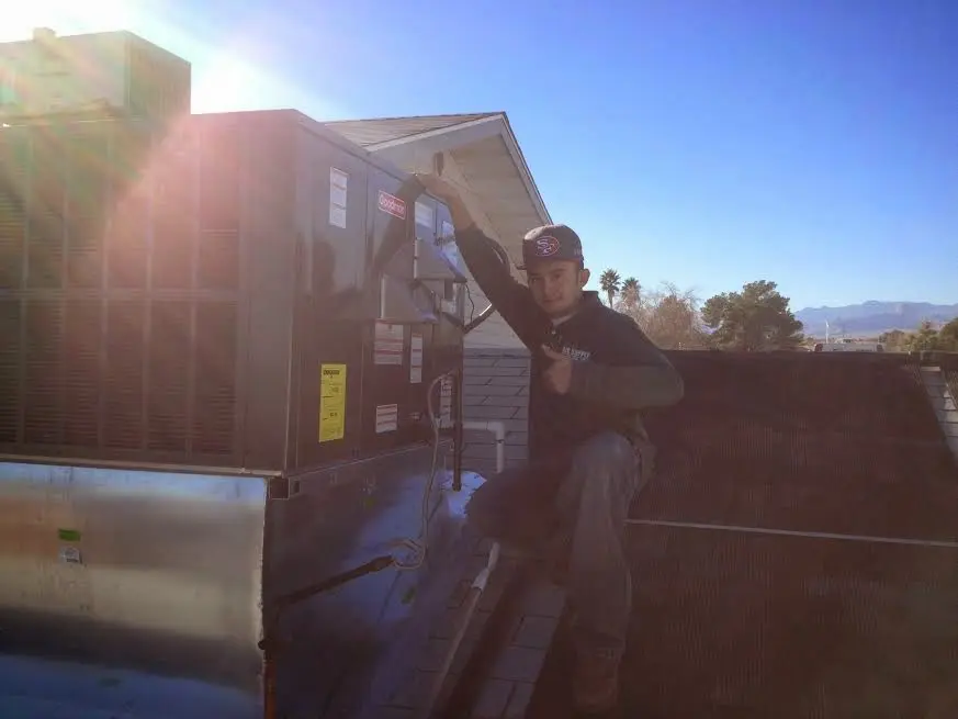 HVAC technician performing AC Tune-Up on a rooftop unit in Tehachapi